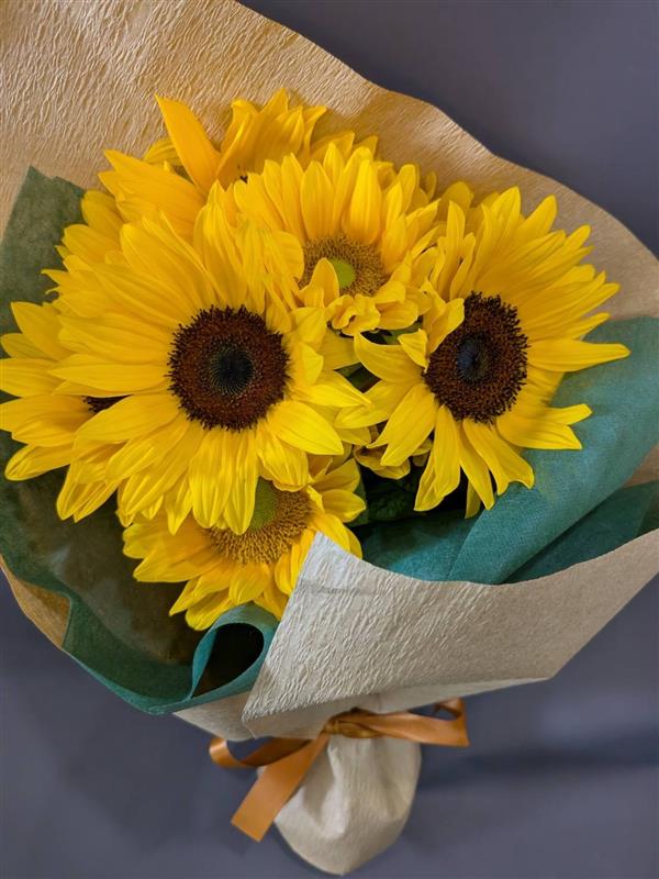 淡いピンクと白の花を束ねた手渡し用の花束